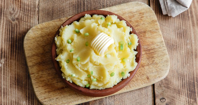 Mashed potatoes in a bowl with butter and chives