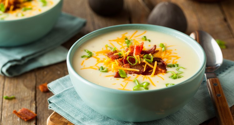 Potato soup in a bowl topped with bacon and cheddar cheese