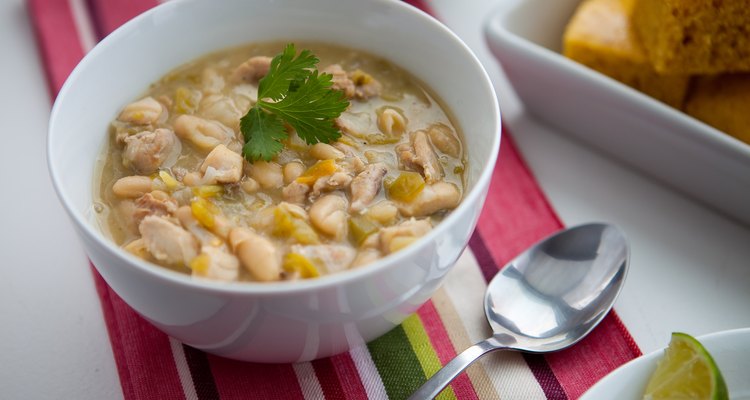 Crock-pot white chicken chili in a bowl with lime and cornbread