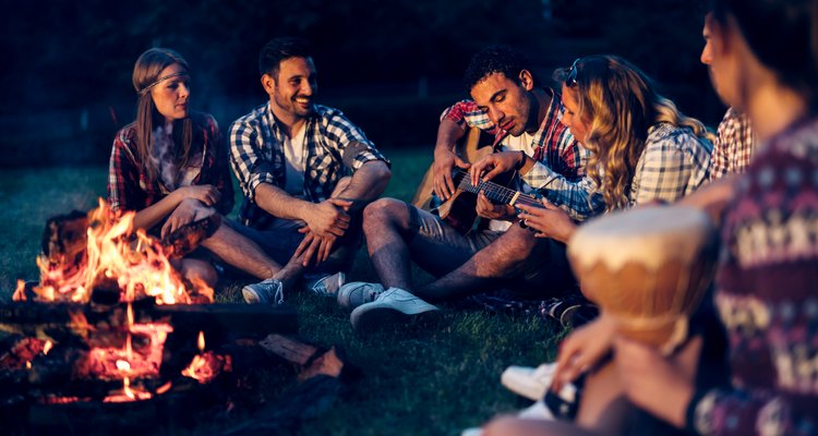 Friends enjoying music near campfire