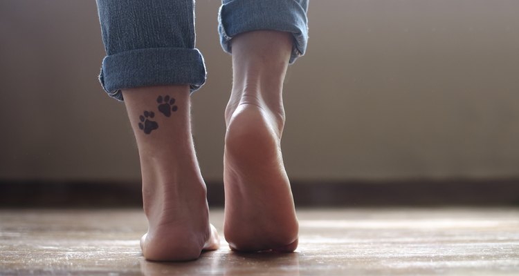 Close-up of a girl's ankles with a tattoo of dog paws