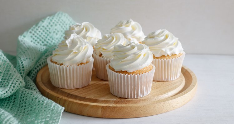 Homemade vanilla cupcakes on a wooden serving plate