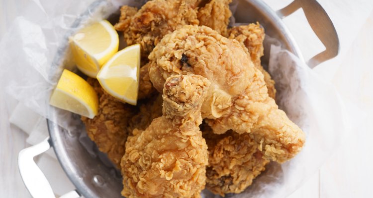 Easy fried chicken pieces in a serving dish with lemon wedges