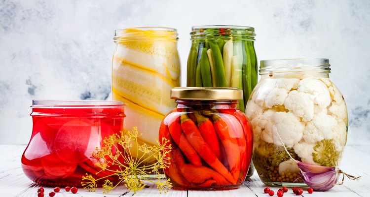 Marinated pickles variety preserving jars. Homemade green beans, squash, radish, red chili peppers, cauliflower pickles. Fermented food.