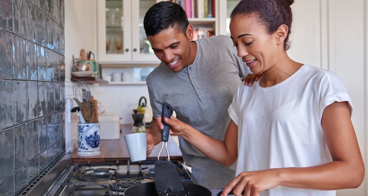 Couple cooking eggs for breakfast in the kitchen