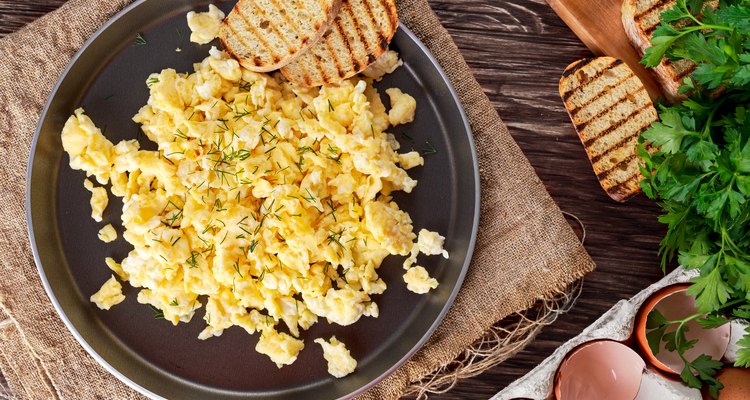 Scrambled eggs on Pan with grilled toast.