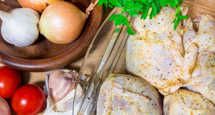 Cooking meat quails in the oven. Whole quail marinovani in spices with onions and mustard. Garnish with fresh potatoes and parsley.