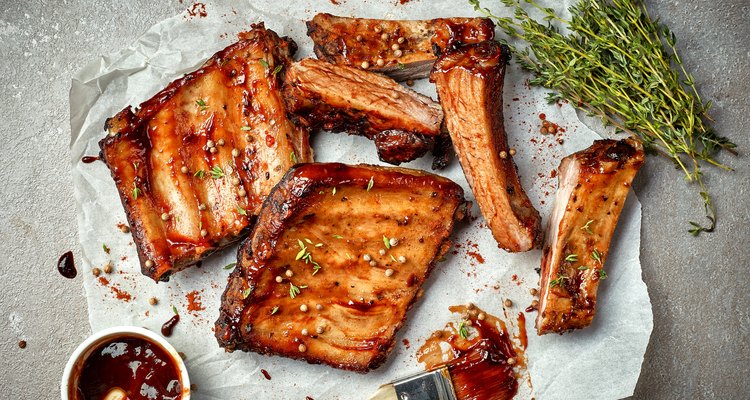 Classic BBQ ribs on parchment paper with BBQ sauce