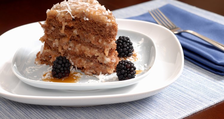 Slice of German chocolate cake on a plate with blackberries