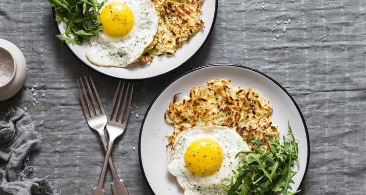 Hash Browns, fried egg and arugula on grey background, top view. Delicious simple lunch