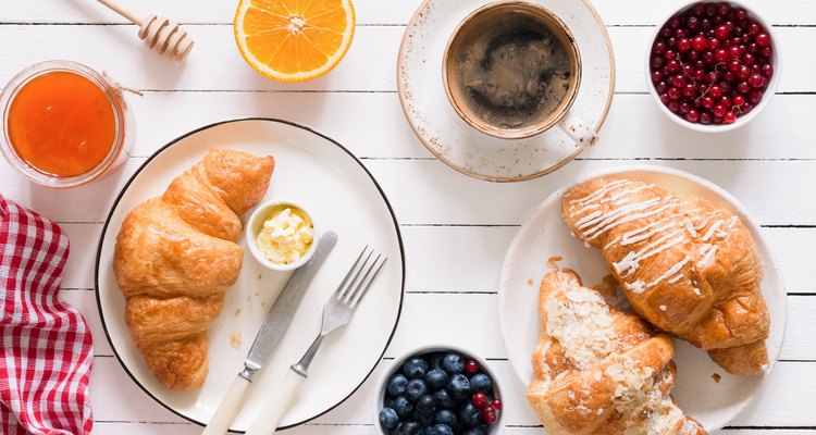 Croissants, coffee, jam and fruits. Continental breakfast table top view