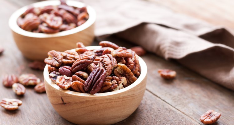 Pecan nuts in wooden bowel on wooden