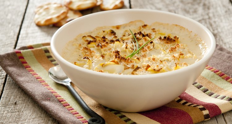 Baked artichoke dip in a dish with spoon and crackers
