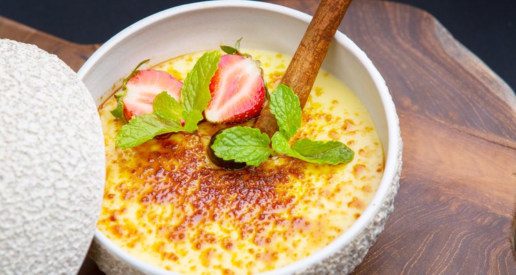 Creme brulee - traditional french vanilla cream dessert with strawberries and mint leaf on the top