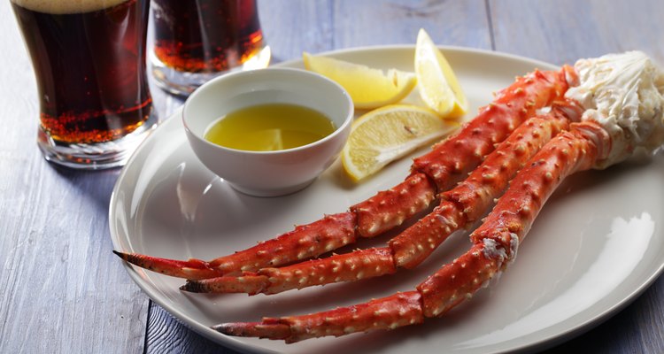 Crab legs on a serving platter with butter and lemon wedges