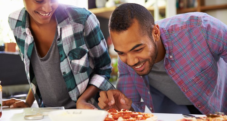 Young Couple making pizza in kitchen together
