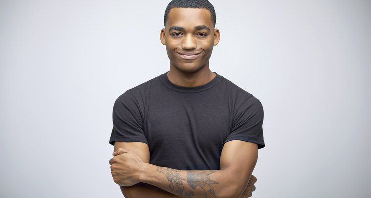 Portrait of smiling tattooed man with arms crossed