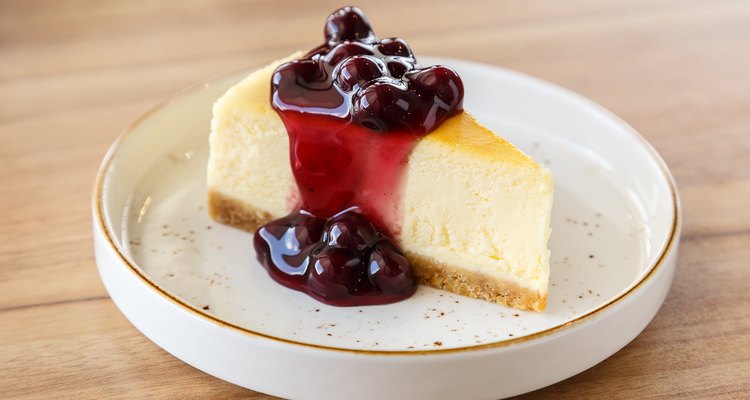 Homemade New York cheesecake with blueberry sauce on a wooden table