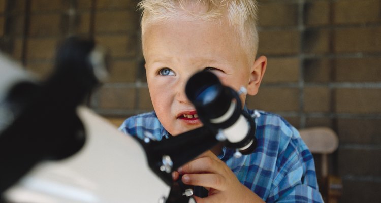 A caucasian boy plays with his telescope