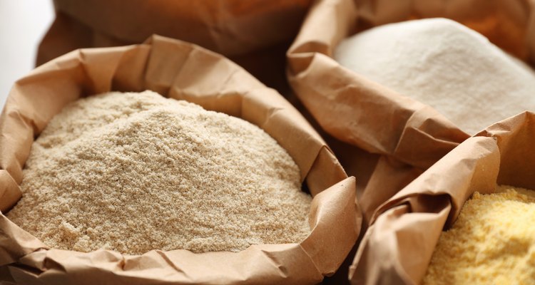 Paper bags with different types of flour, closeup