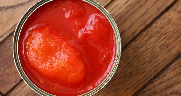 Whole can of tomatoes isolated from above on wood.