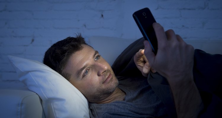 man in couch using mobile phone neetworking late night