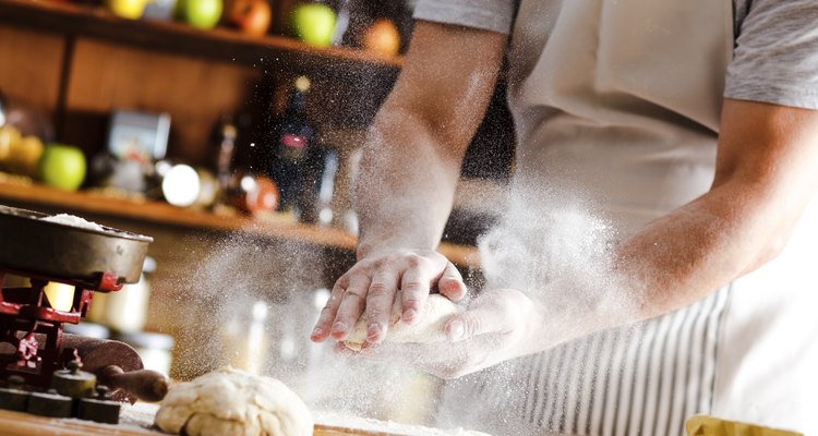 Close up of male baker hands kneading dough
