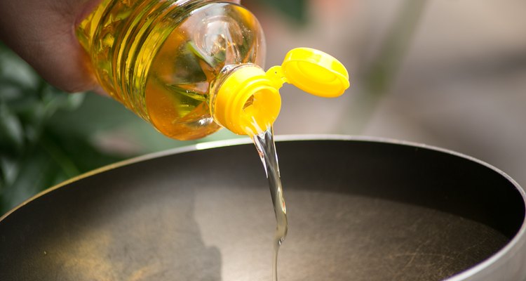 Pouring food oil in hot pan for deep frying.