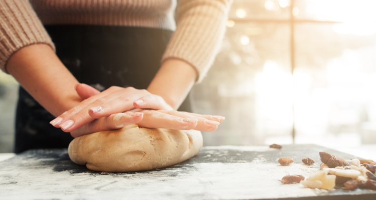 Woman's hands kneading dough in a kitchen