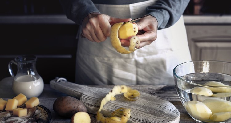 Peeling potatoes on the wooden table horizontal