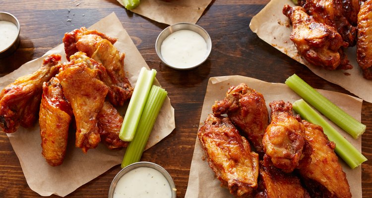 different flavored chicken wings on wooden table