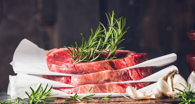 Stack of  raw steaks with rosemary