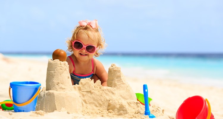Little girl building sand castles on beach