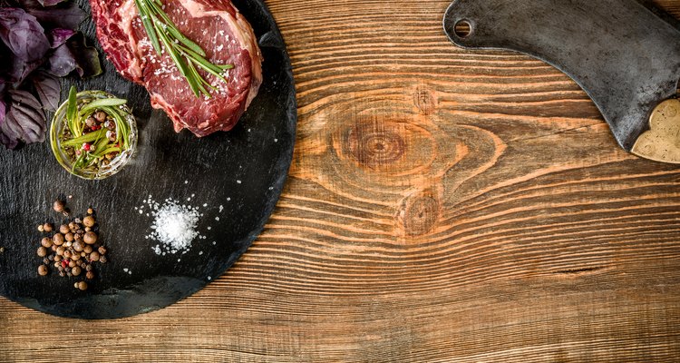 Dry aged raw beef steak with ingredients for grilling