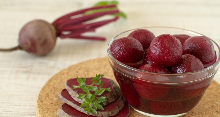 Small pickled beetroots inj a bowl and fresh ingredients