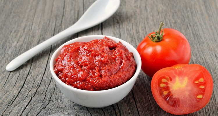 Tomato sauce in a white bowl and fresh tomatoes