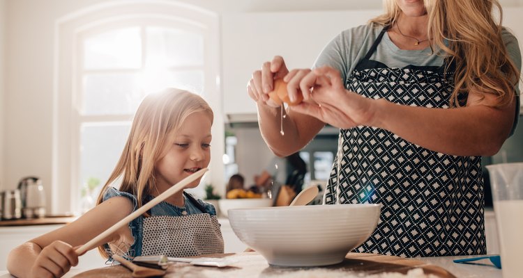 Mother and daughter preparing food in kitchen