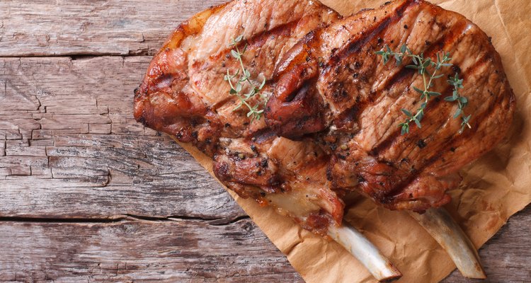 two pieces of grilled pork an old table top view