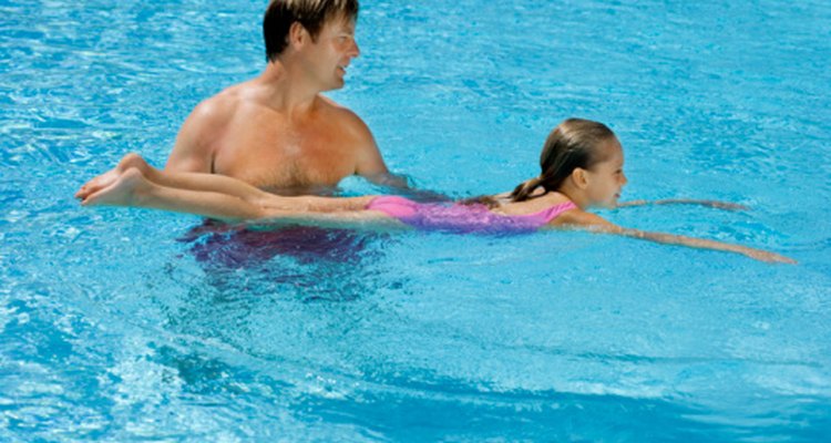 En las clases de natación se les enseña a los niños a flotar en el agua.