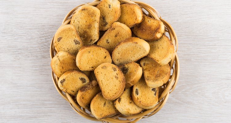 Small rusks with raisin in wicker basket on wooden table