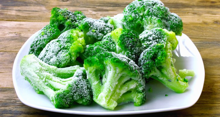 Frozen broccoli pieces on a white plate