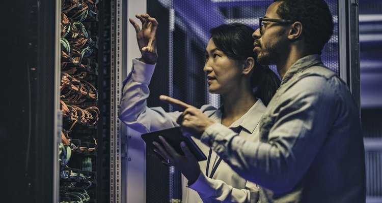 Female Asian IT technician explaining network connection to a novice engineer