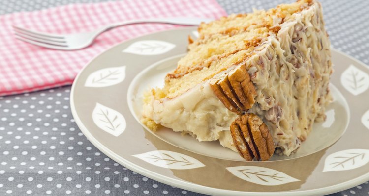 Homemade Italian cream cake garnished with pecans on a plate