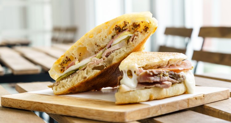 Cuban sandwich on a cutting board on a wooden table