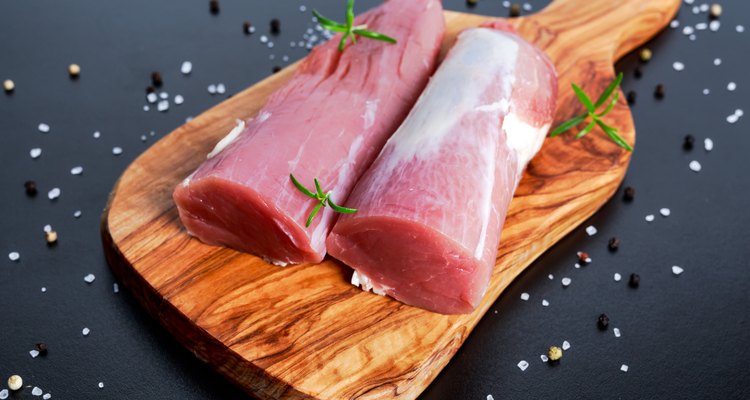 Fresh Raw pork tenderloin on wooden board .ready to cook