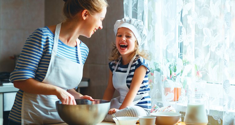 happy family in kitchen. mother and child preparing dough, bake cookies