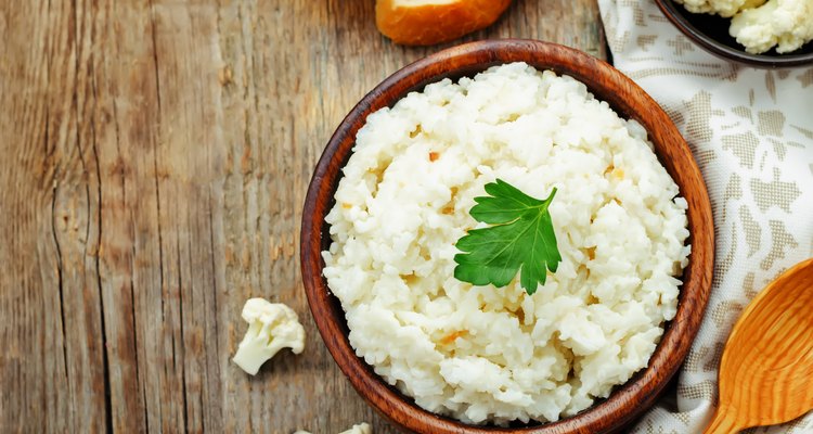 Creamy cauliflower garlic rice in a bowl on a wooden table