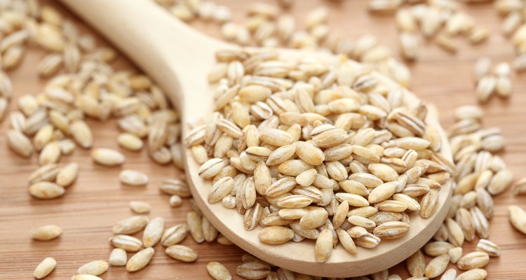 Pearl barley in a wooden spoon