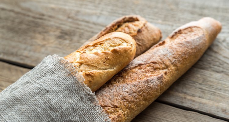 Three baguettes on the wooden background