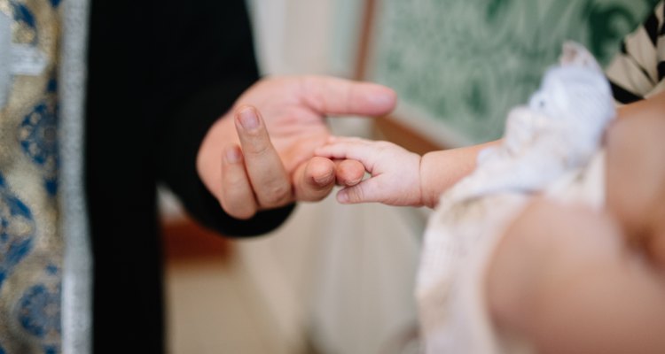holding baby hand during christening